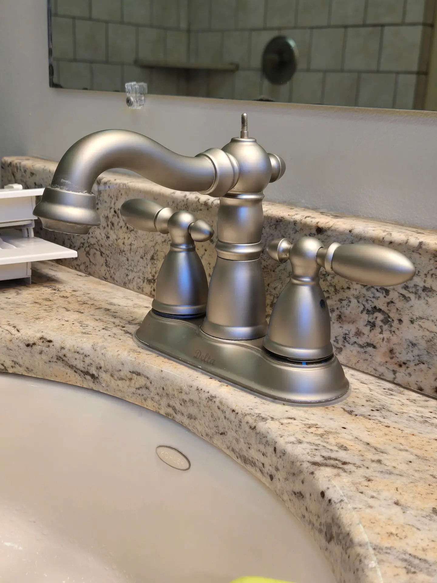 Brushed nickel bathroom faucet on a granite vanity