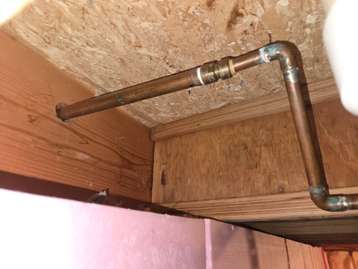 Copper water line running through a ceiling cavity